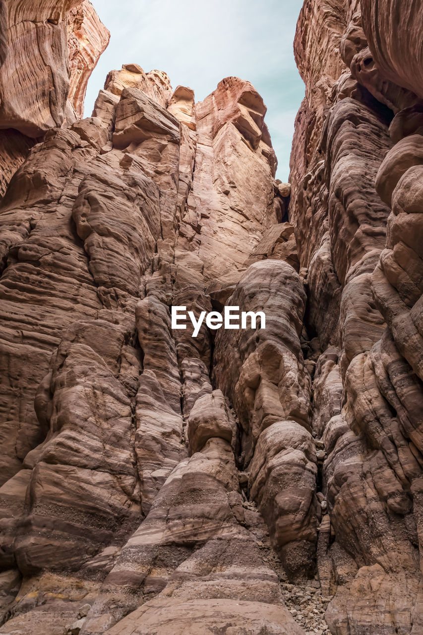 rock, rock formation, arch, travel destinations, nature, geology, travel, scenics - nature, beauty in nature, no people, environment, wadi, non-urban scene, landscape, formation, canyon, sky, land, sandstone, desert, physical geography, terrain, day, eroded, tranquility, outdoors, low angle view, mountain, ancient history, tourism, climate, valley, cliff, extreme terrain