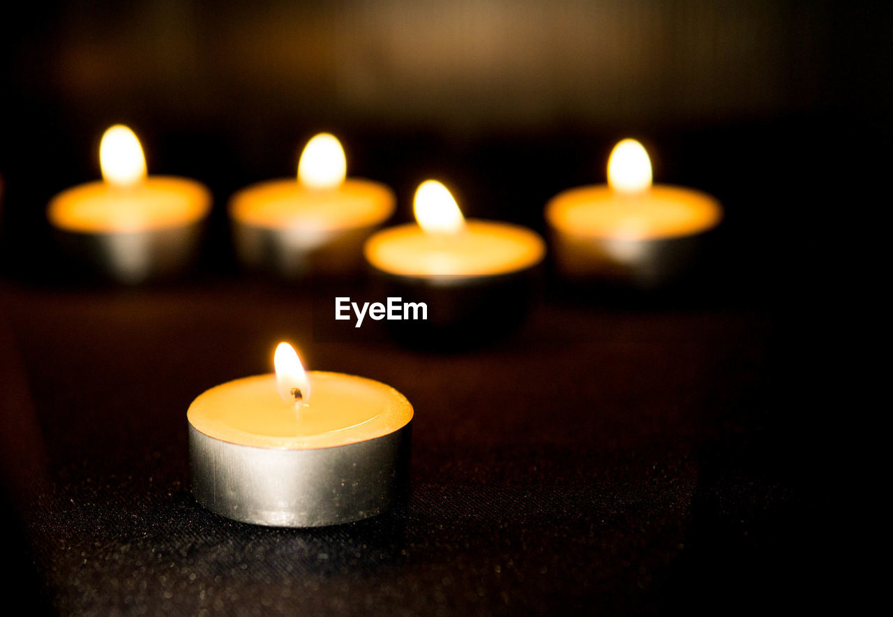 Many candles burn with a shallow depth of field.