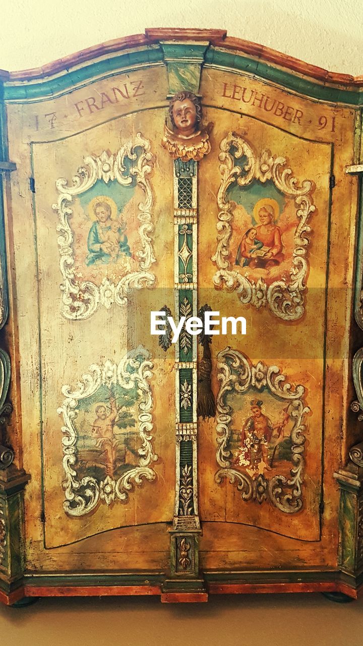 CLOSE-UP OF ORNATE DOOR KNOCKER ON OLD WOODEN WALL