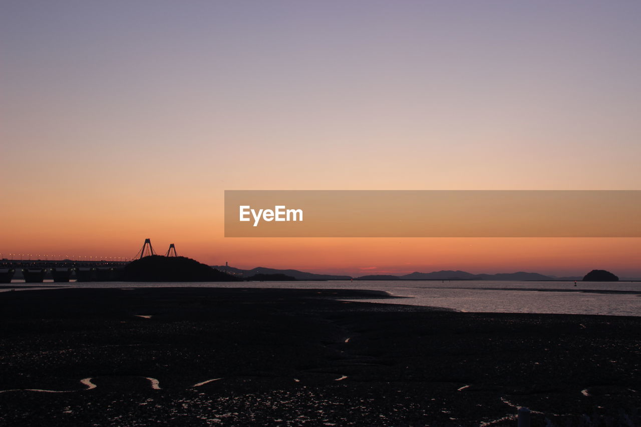 Scenic view of sea against clear sky during sunset