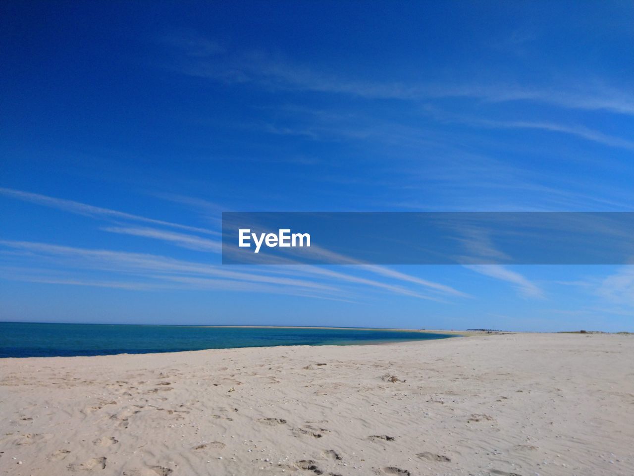 Scenic view of beach against blue sky