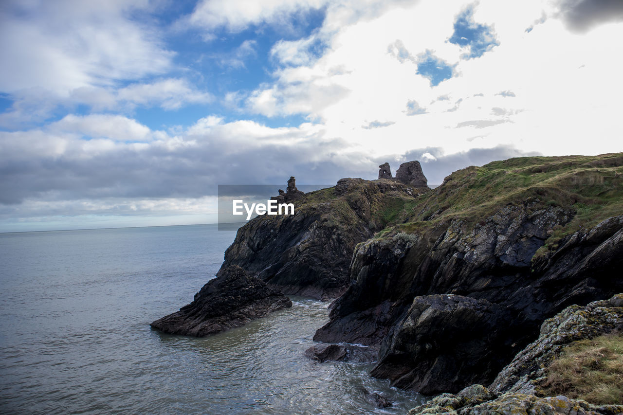 Rock formations by sea against sky