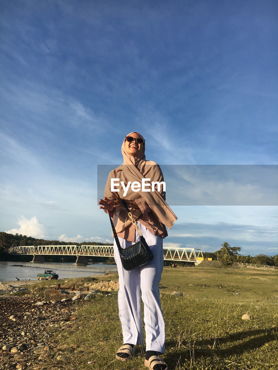 Full length of woman standing on field against sky