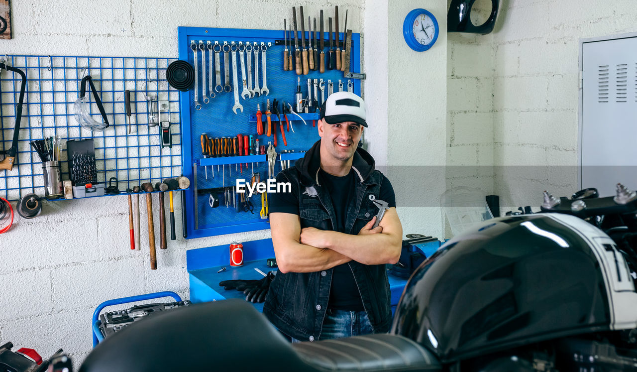 Portrait of man by motorcycle in garage