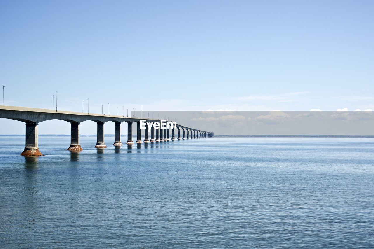 Bridge over sea against blue sky