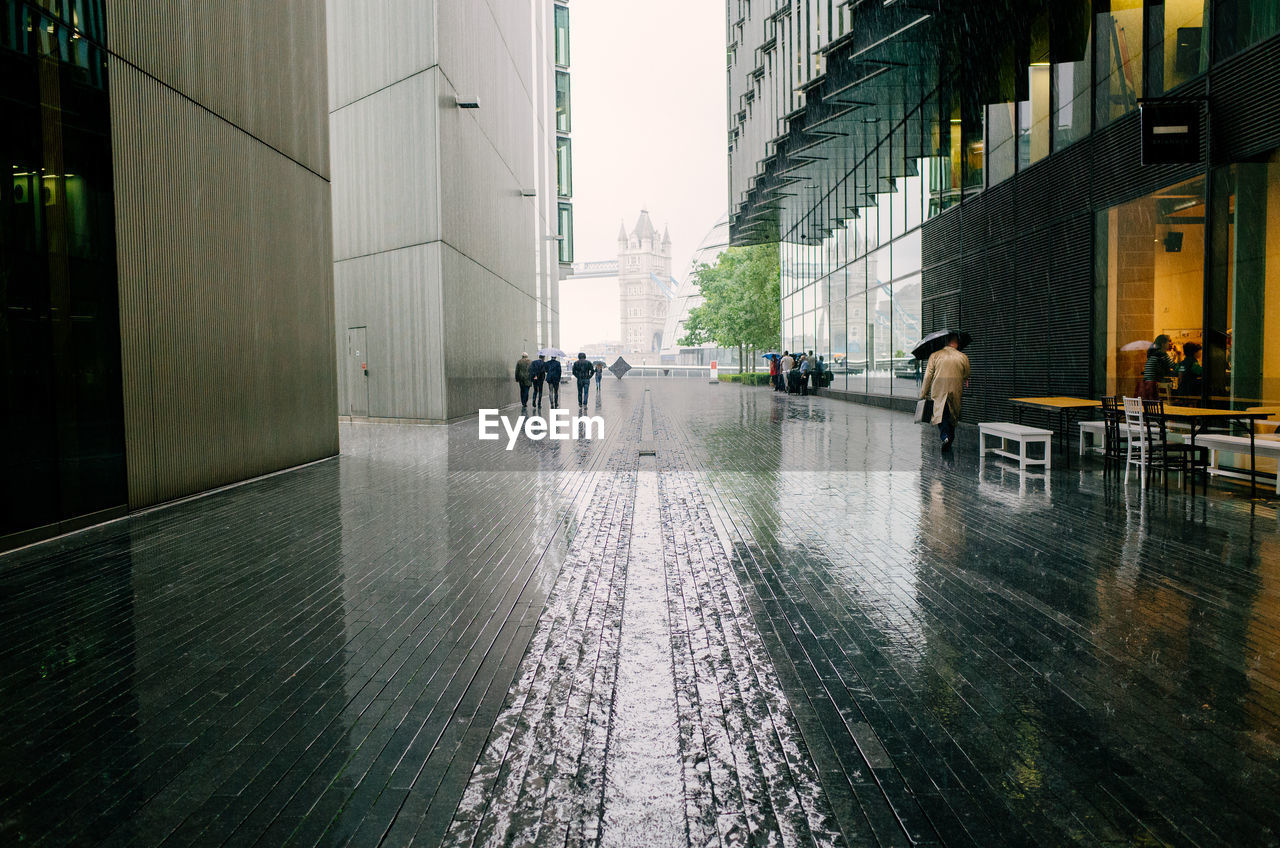 People walking between through vauxhall in the rain in london