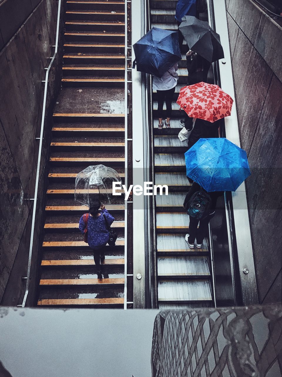 High angle view of people on steps and escalator during rainy season