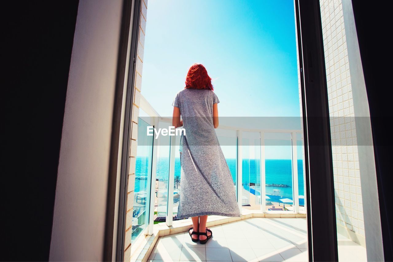 Rear view of woman standing on balcony