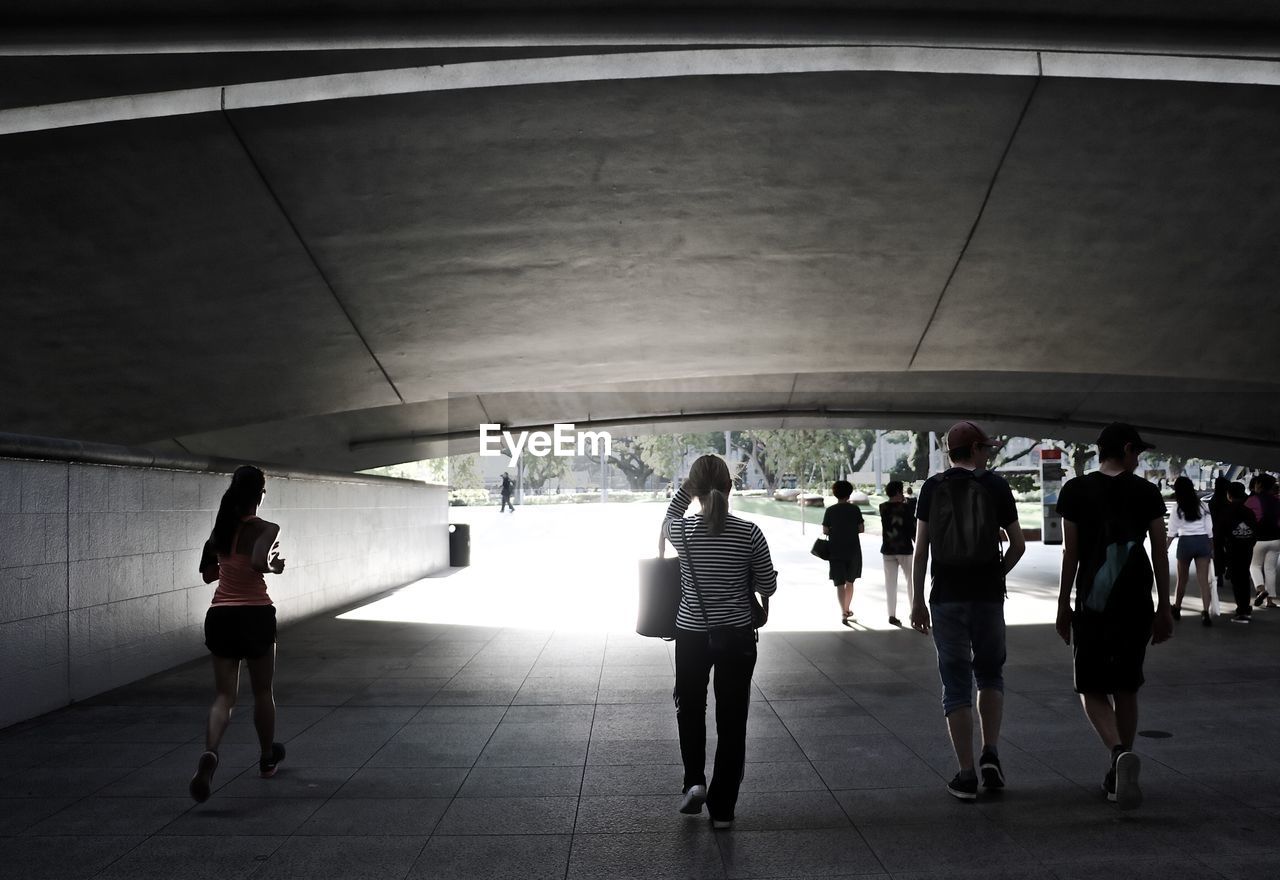 REAR VIEW OF PEOPLE WALKING IN CORRIDOR