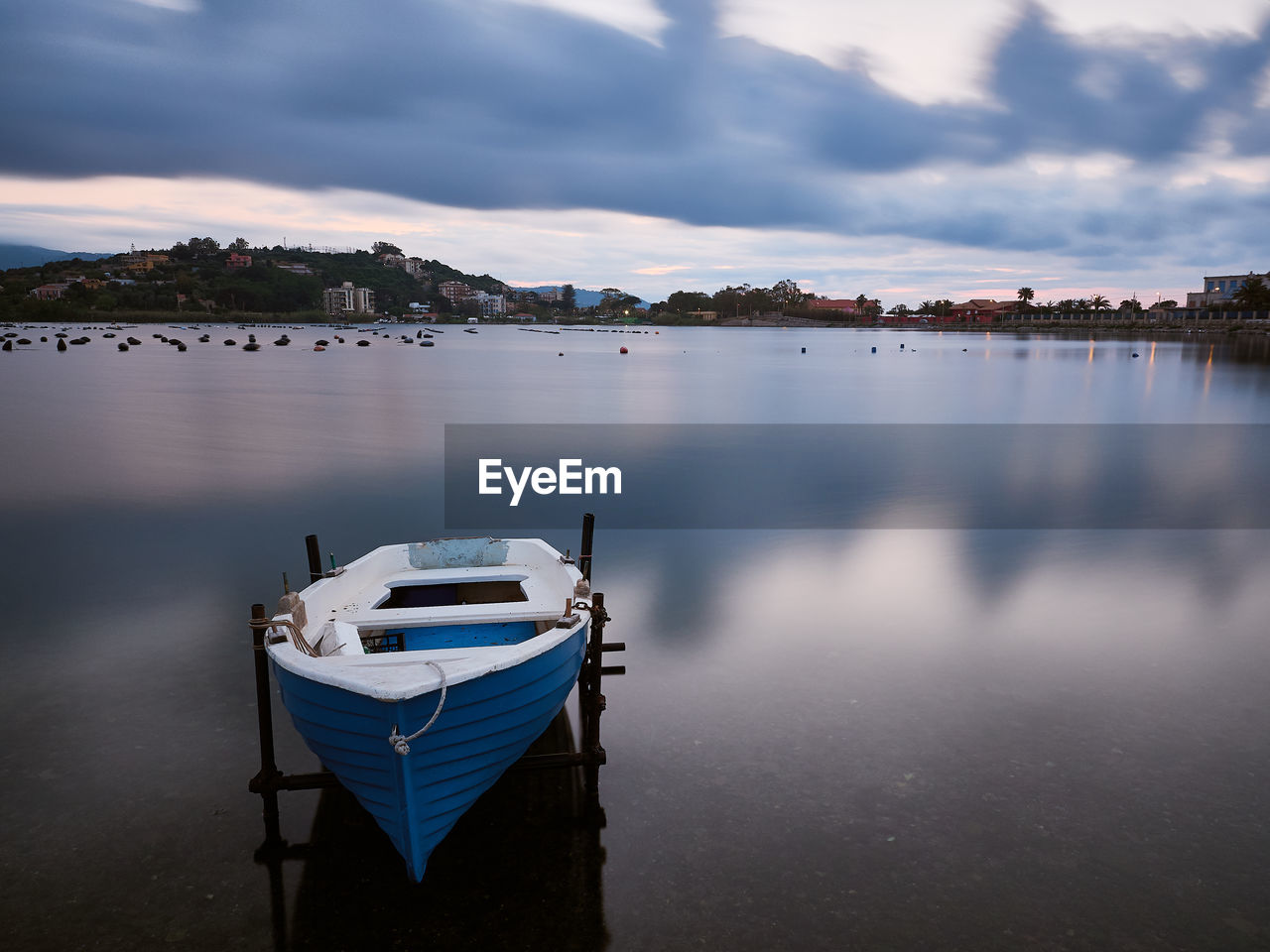 Boat moored in lake against sky