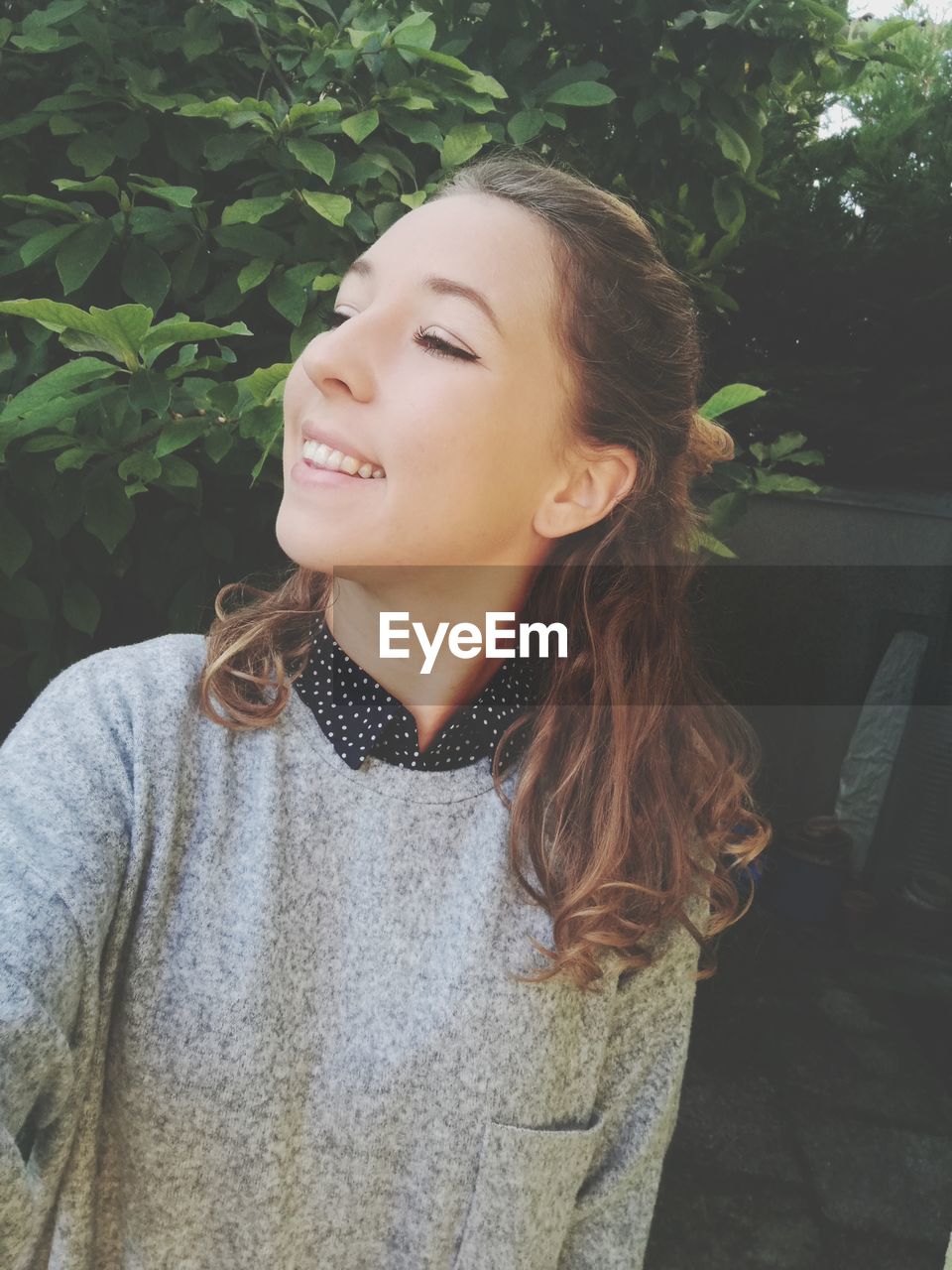 Tilt shot of smiling young woman in back yard