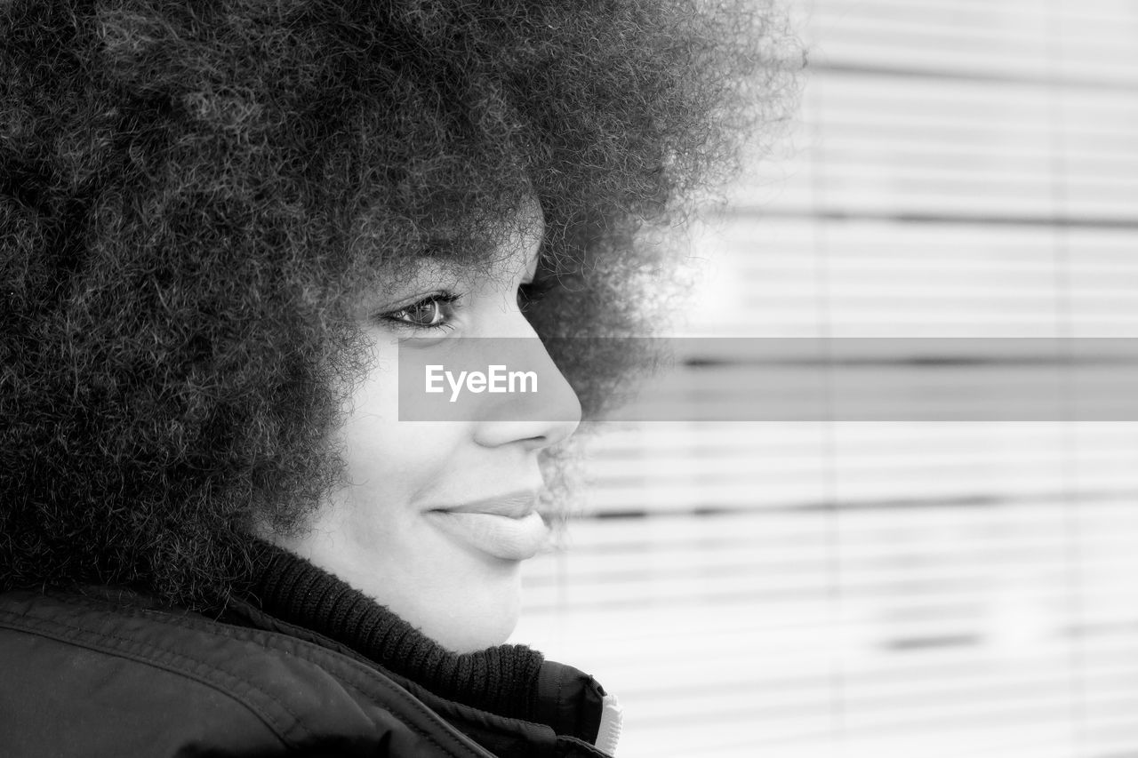 Close-up of young woman with curly hair in city