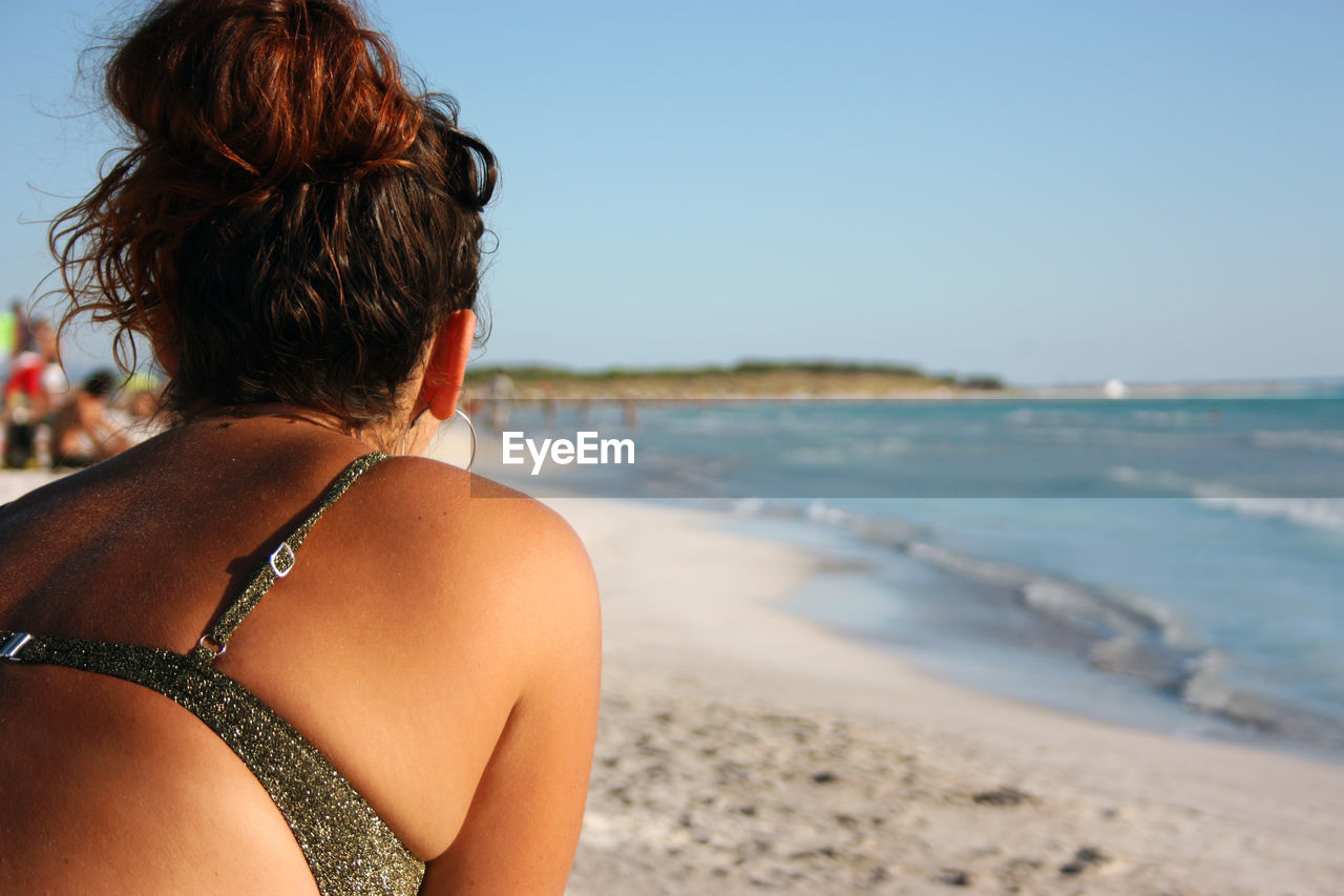 REAR VIEW OF WOMAN LOOKING AT SEA AGAINST SKY