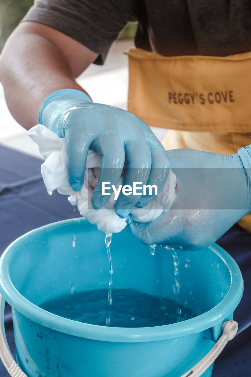 CLOSE-UP OF HAND POURING WATER IN GLASS