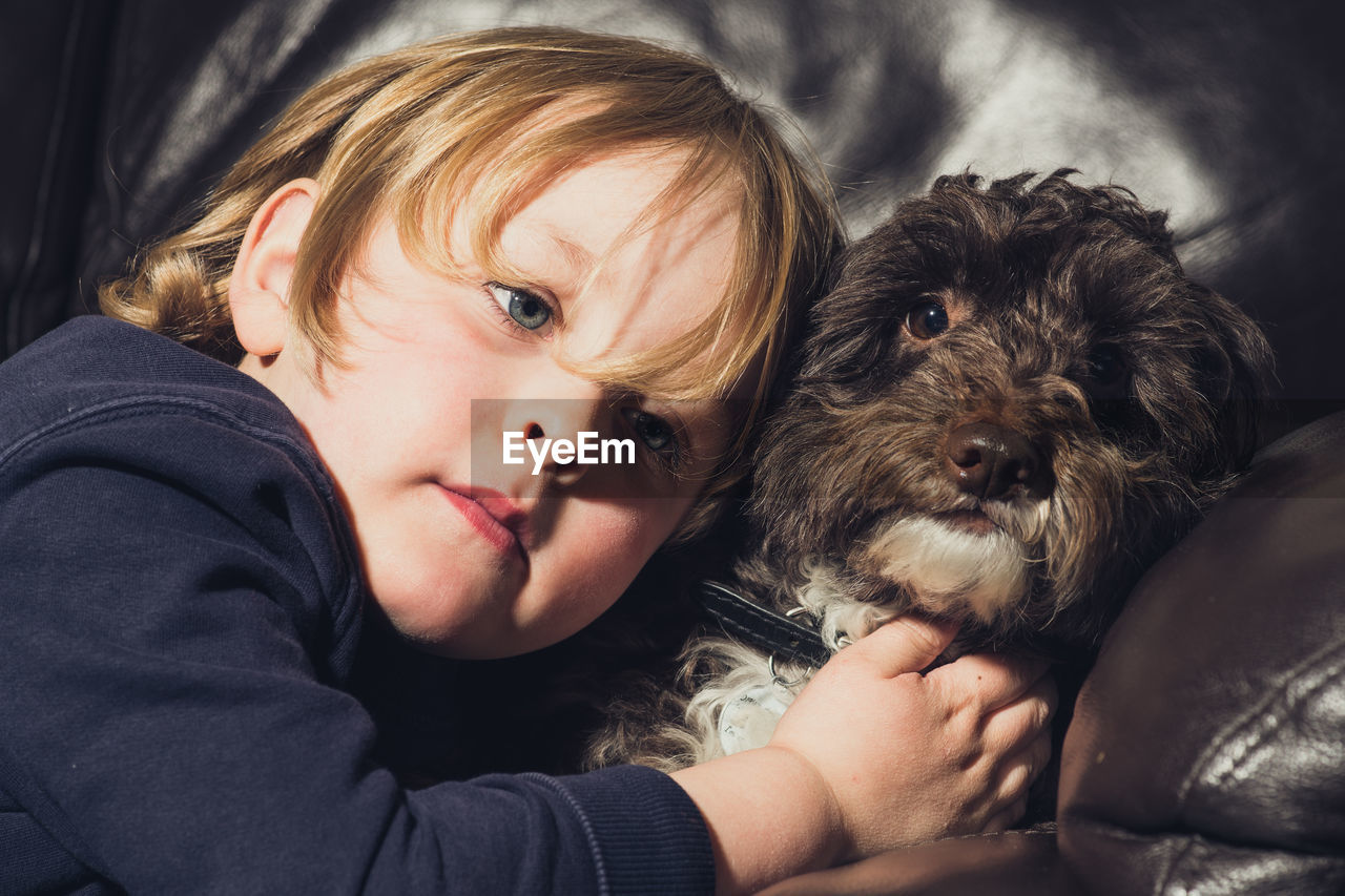 Boy with dog looking away a home