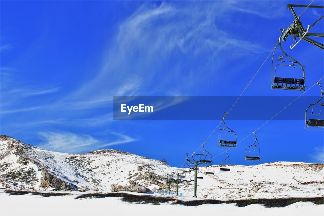 Snow covered mountain against blue sky with empty cable car. stock photo 