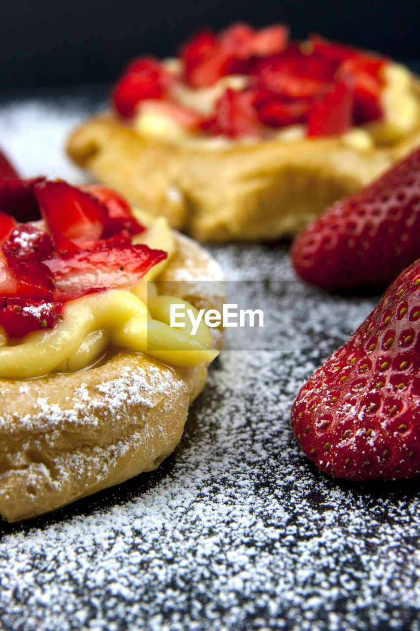 Close-up of custard pastries with strawberries