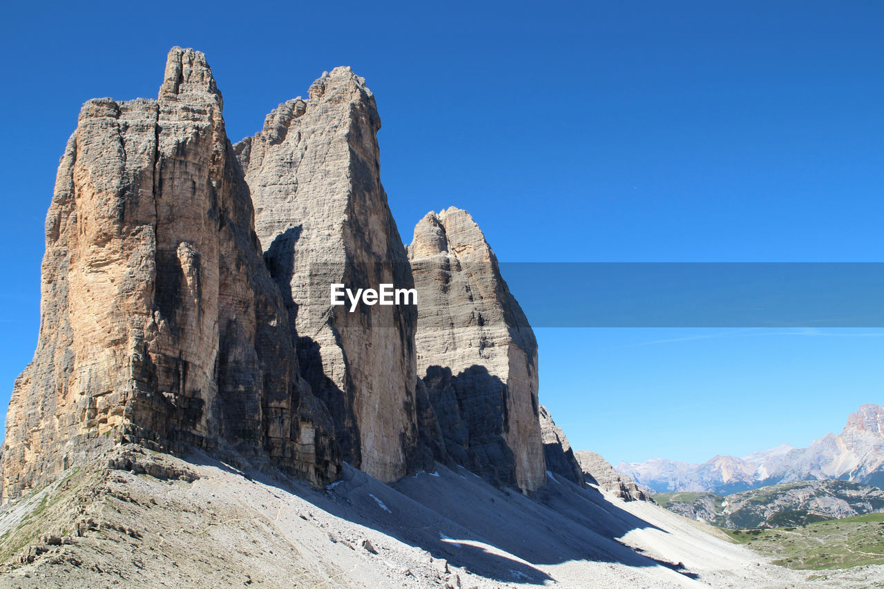 Panoramic view of rock formation against clear blue sky