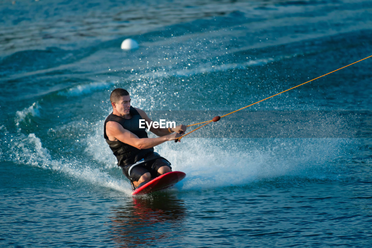 Mid adult man kiteboarding on sea