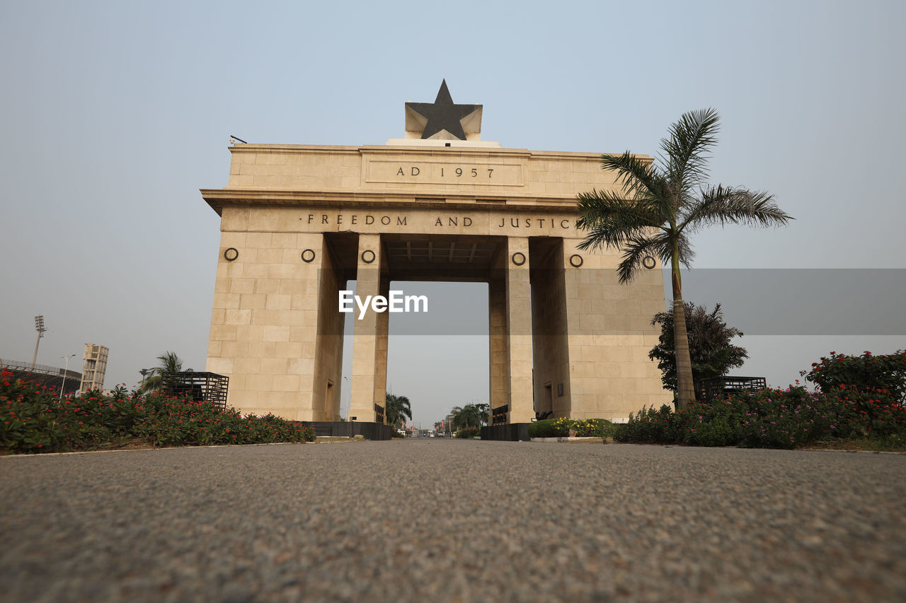 architecture, travel destinations, history, built structure, sky, the past, nature, travel, city, landmark, plant, memorial, clear sky, architectural column, tree, tourism, monument, building exterior, no people, outdoors, city gate, temple, day, gate, low angle view, animal, street