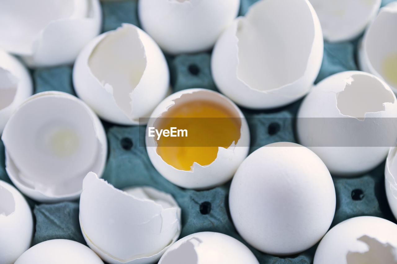 High angle view of broken egg shells in crate