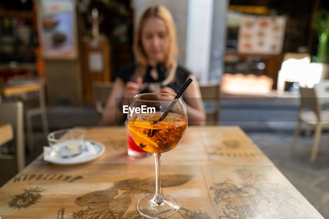 WOMAN WITH DRINK ON TABLE