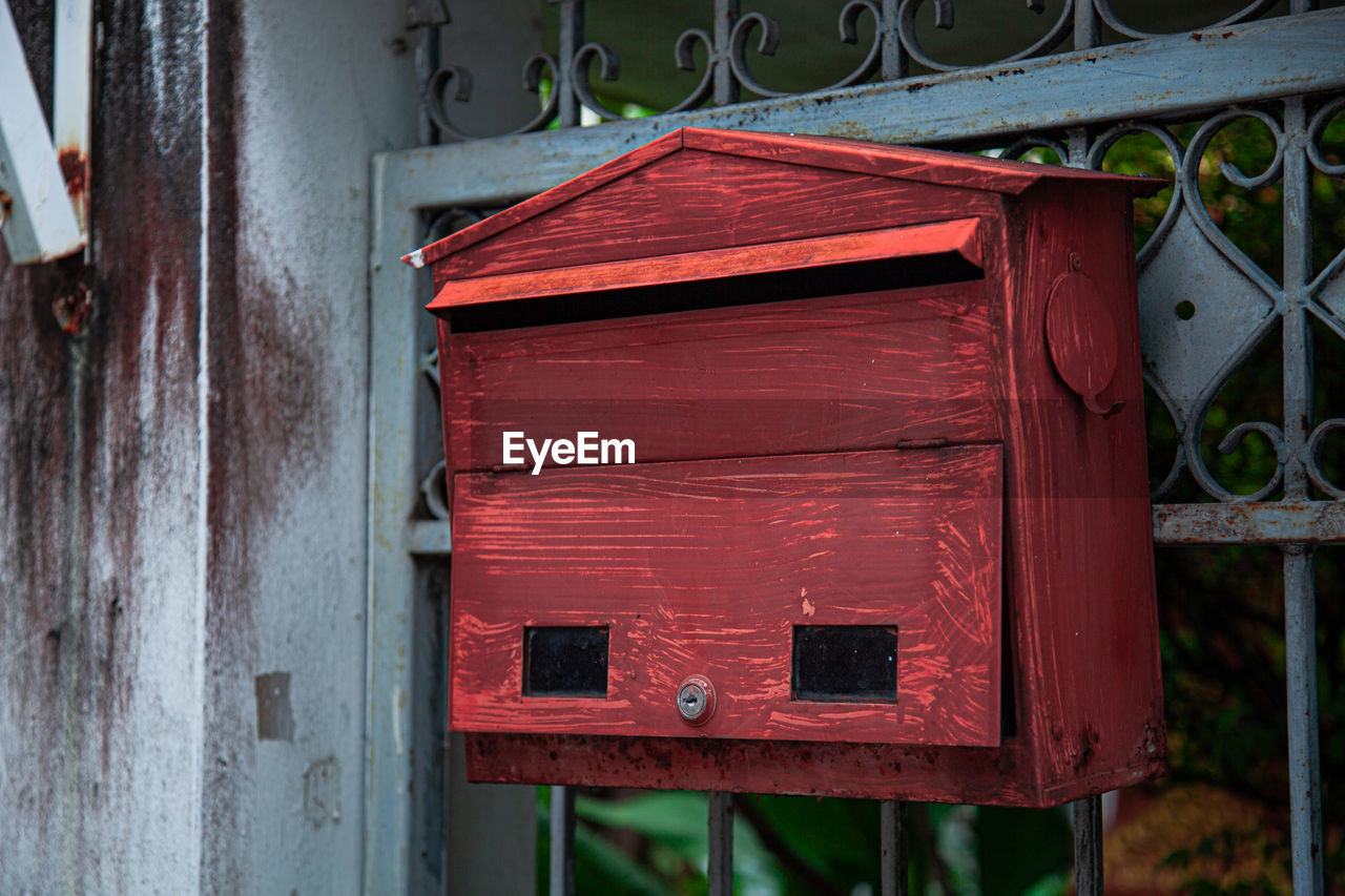 CLOSE-UP OF RED MAILBOX ON WALL