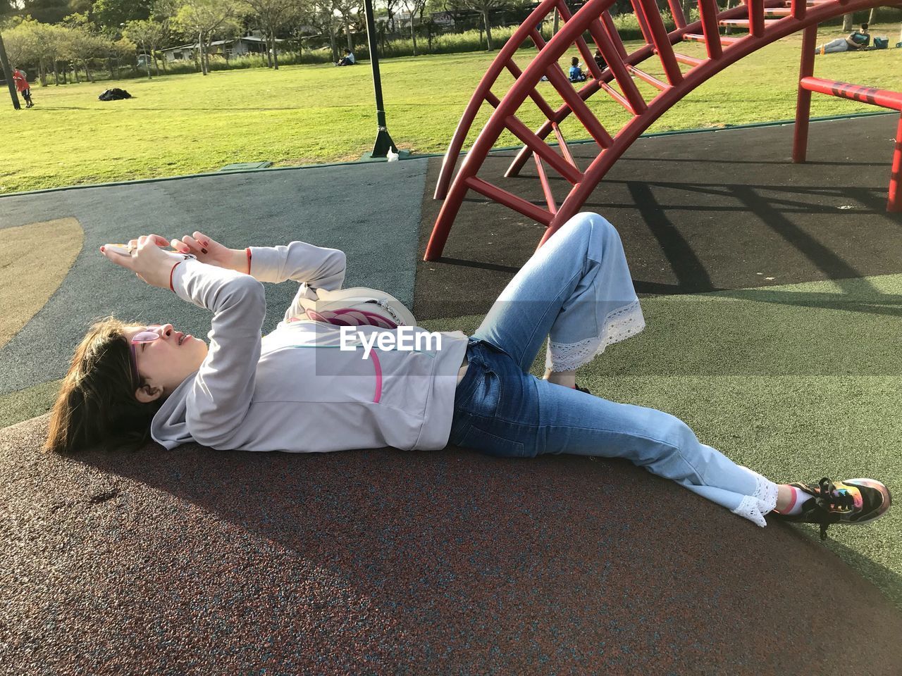 REAR VIEW OF SIBLINGS LYING DOWN AT PARK