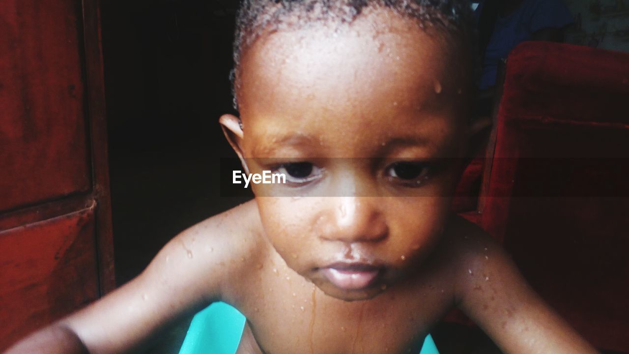 Close-up of shirtless baby boy in bathtub at home