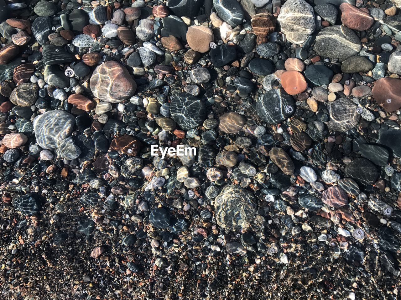 Full frame shot of pebbles in sea 