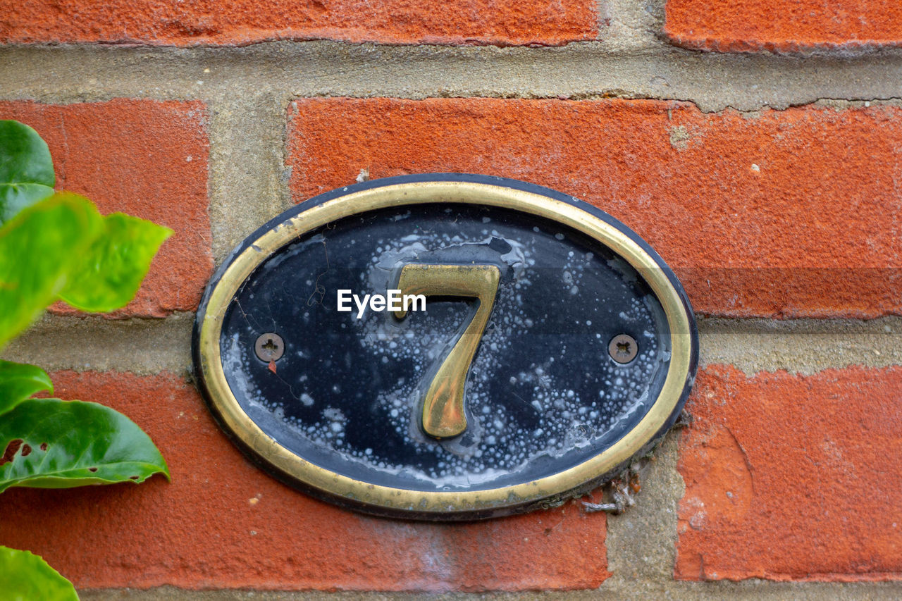 CLOSE-UP OF A RED WALL WITH TEXT ON BRICK