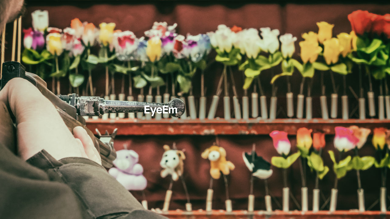 Man aiming at stuffed toys with gun