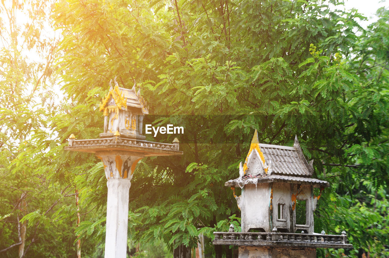 Spirit houses against tree at temple