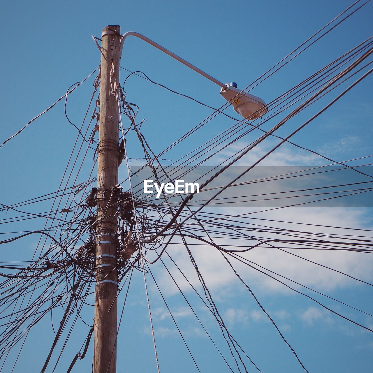 LOW ANGLE VIEW OF POWER LINES AGAINST BLUE SKY AND CLOUDS