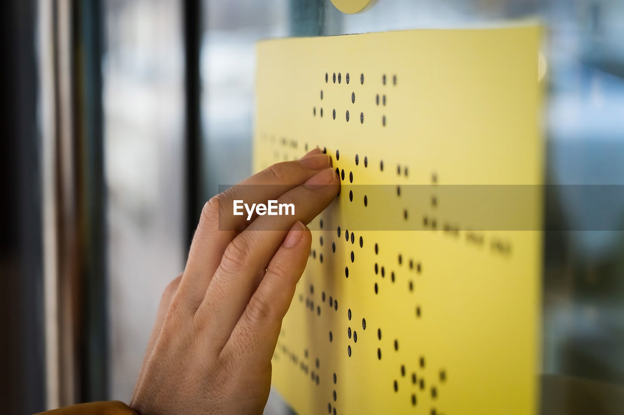 Cropped hand of blind woman reading