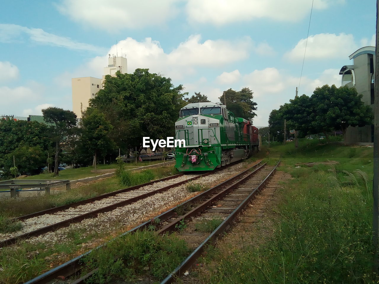 TRAIN BY RAILROAD TRACK AGAINST SKY