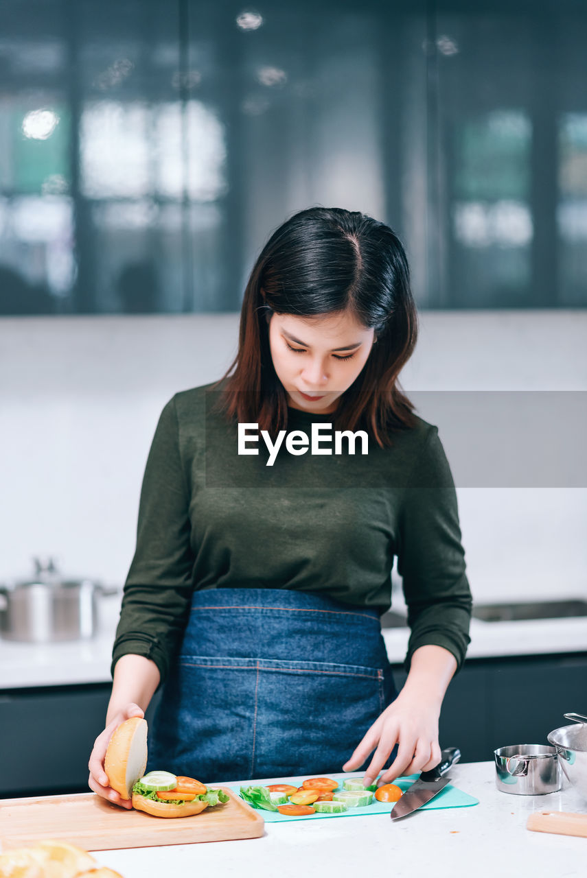 Mid adult woman making sandwich at home