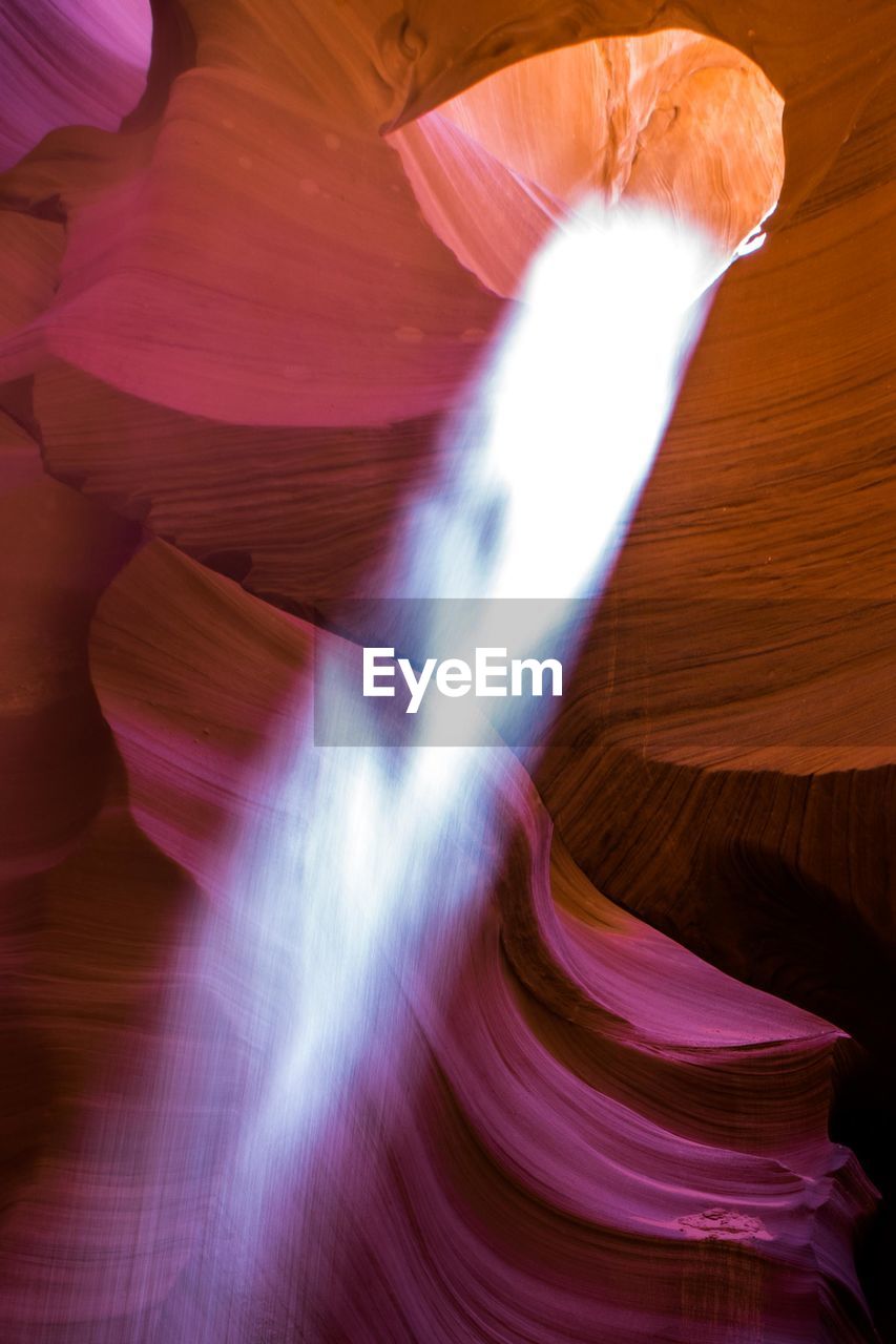 Low angle view of sunlight falling in slot canyon