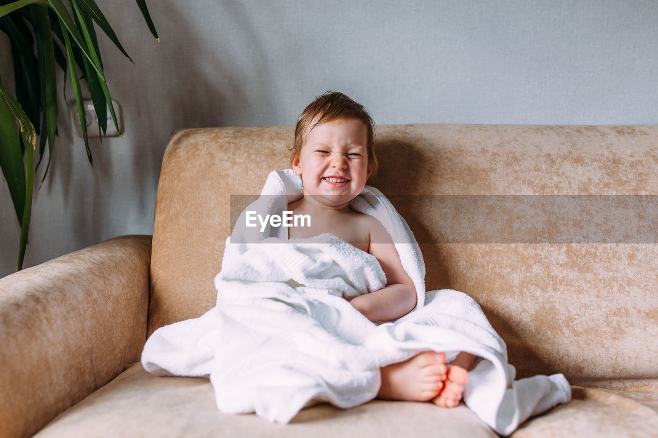 Portrait of smiling girl sitting on sofa