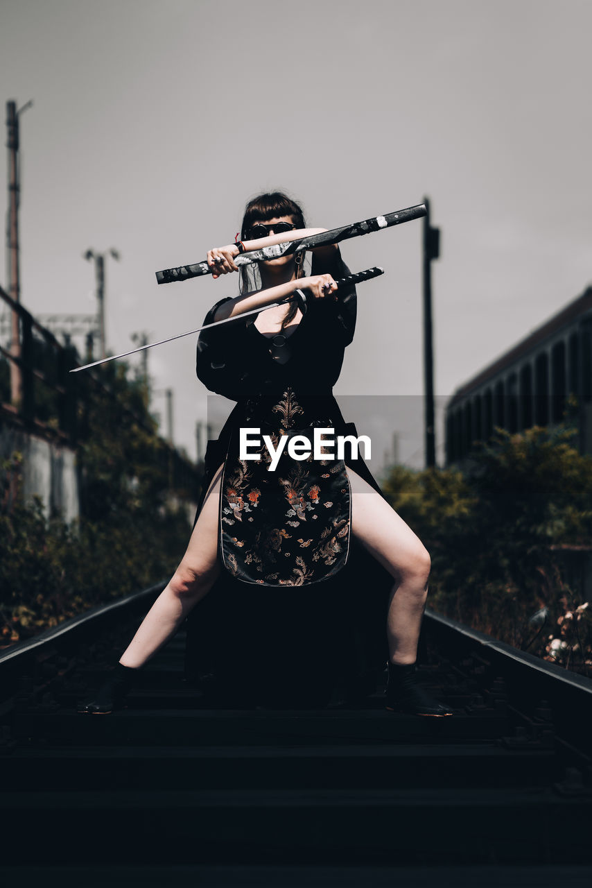 WOMAN STANDING ON RAILROAD TRACK