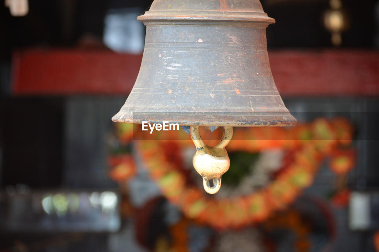 CLOSE-UP OF ILLUMINATED LIGHT BULB HANGING ON WALL