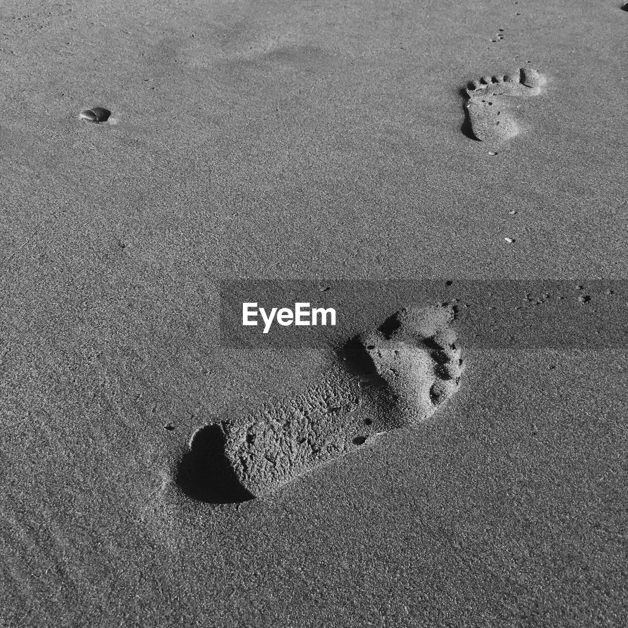 HIGH ANGLE VIEW OF FOOTPRINT ON SAND