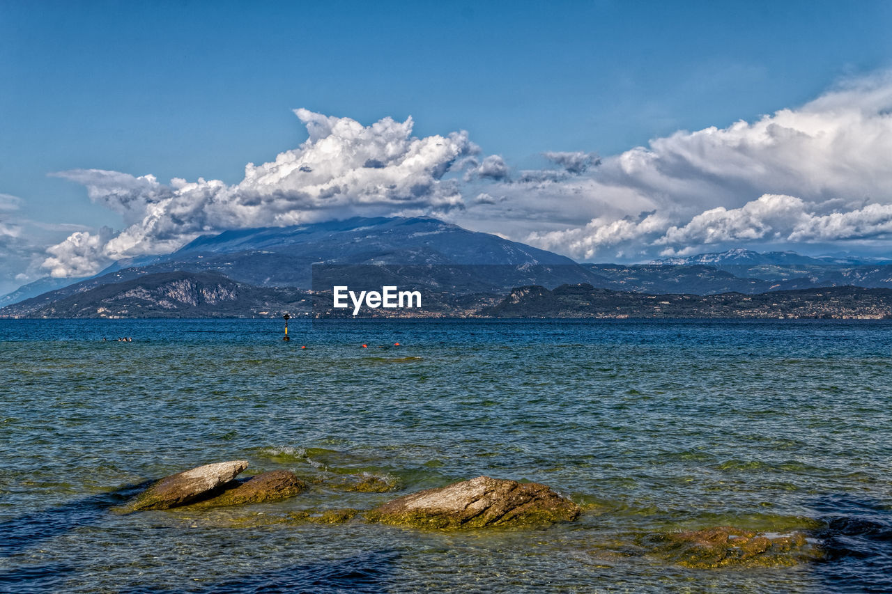 Scenic view of sea and snowcapped mountains against sky