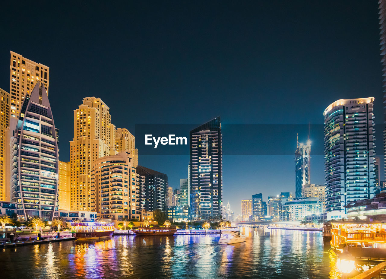 illuminated buildings against clear sky at night