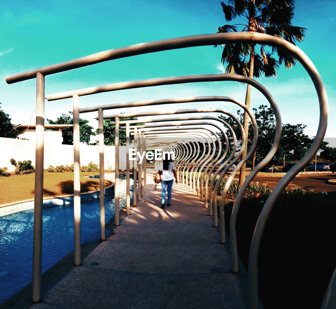 Rear view of woman walking at park sky