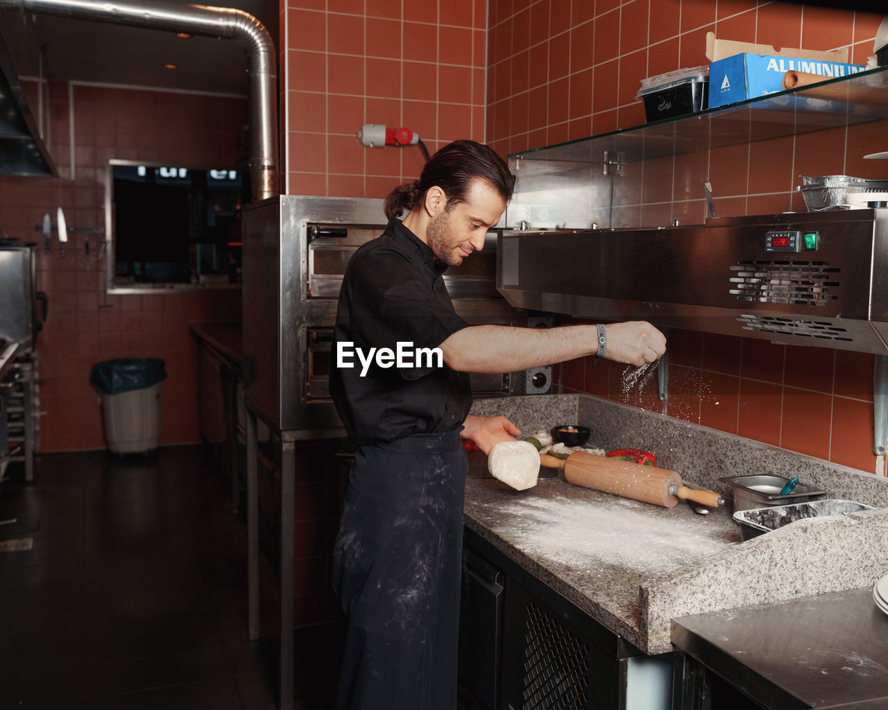 Pizza making process. male chef hands making authentic pizza in the pizzeria kitchen.