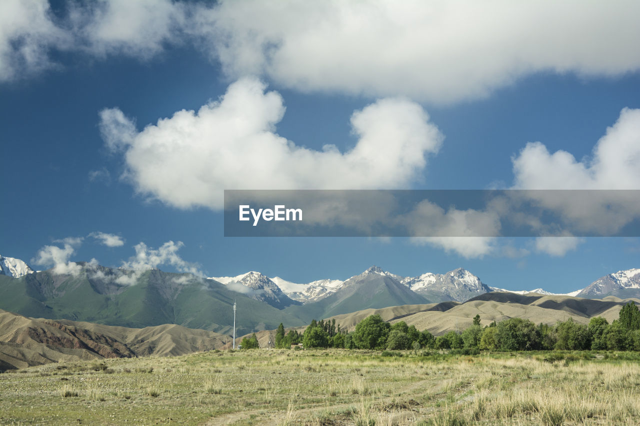 Scenic view of field and mountains against sky