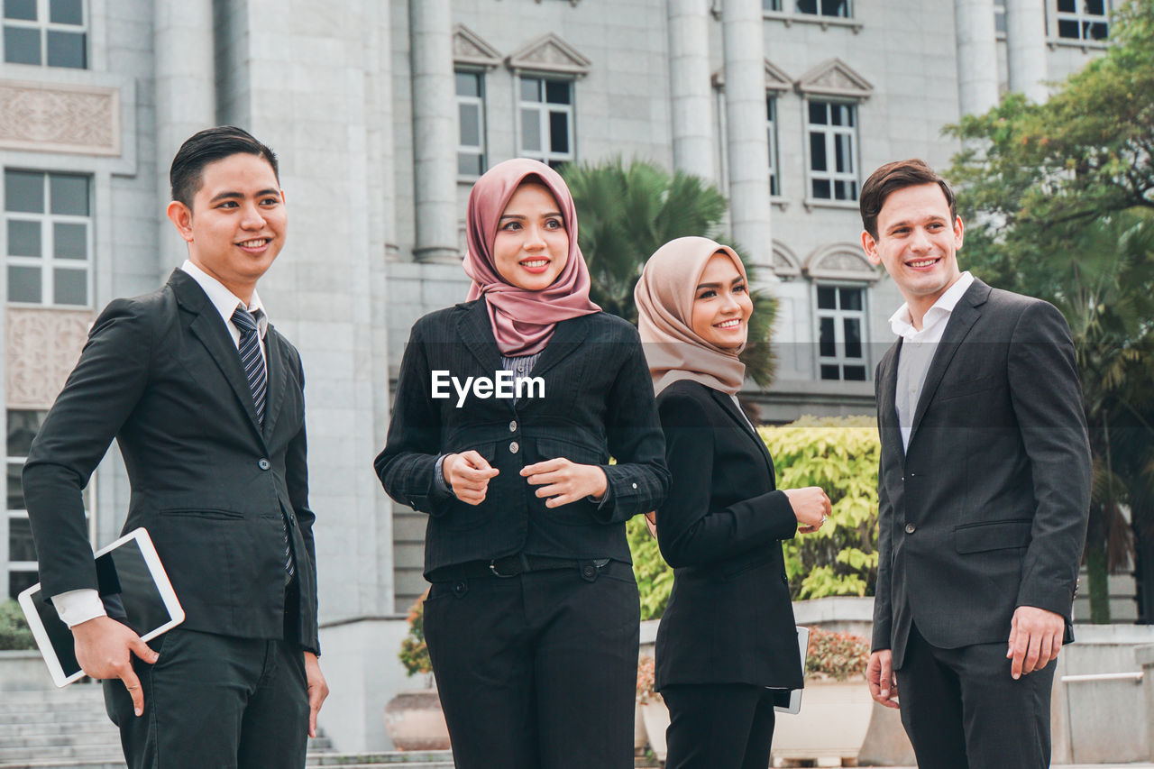 Business people discussing while standing in front of building