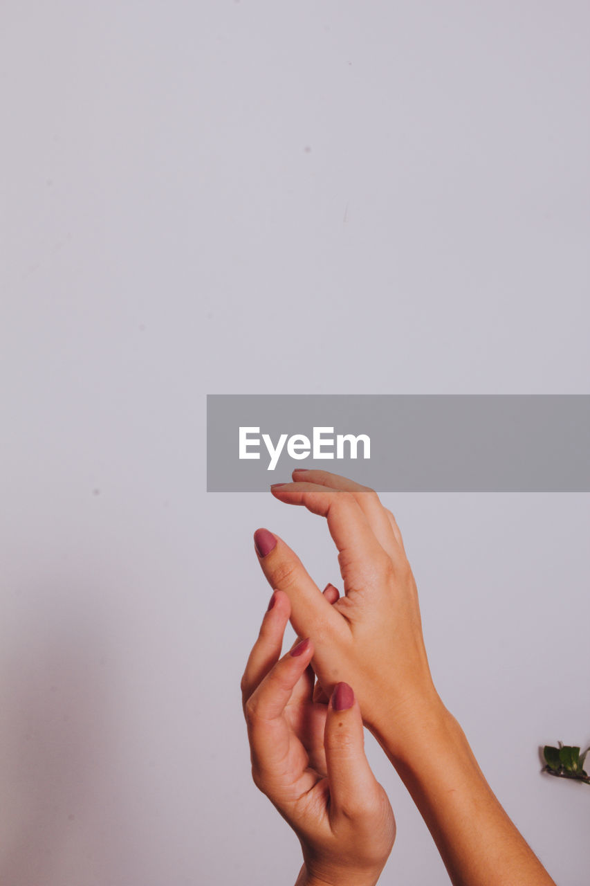 Close-up of woman hand over white background