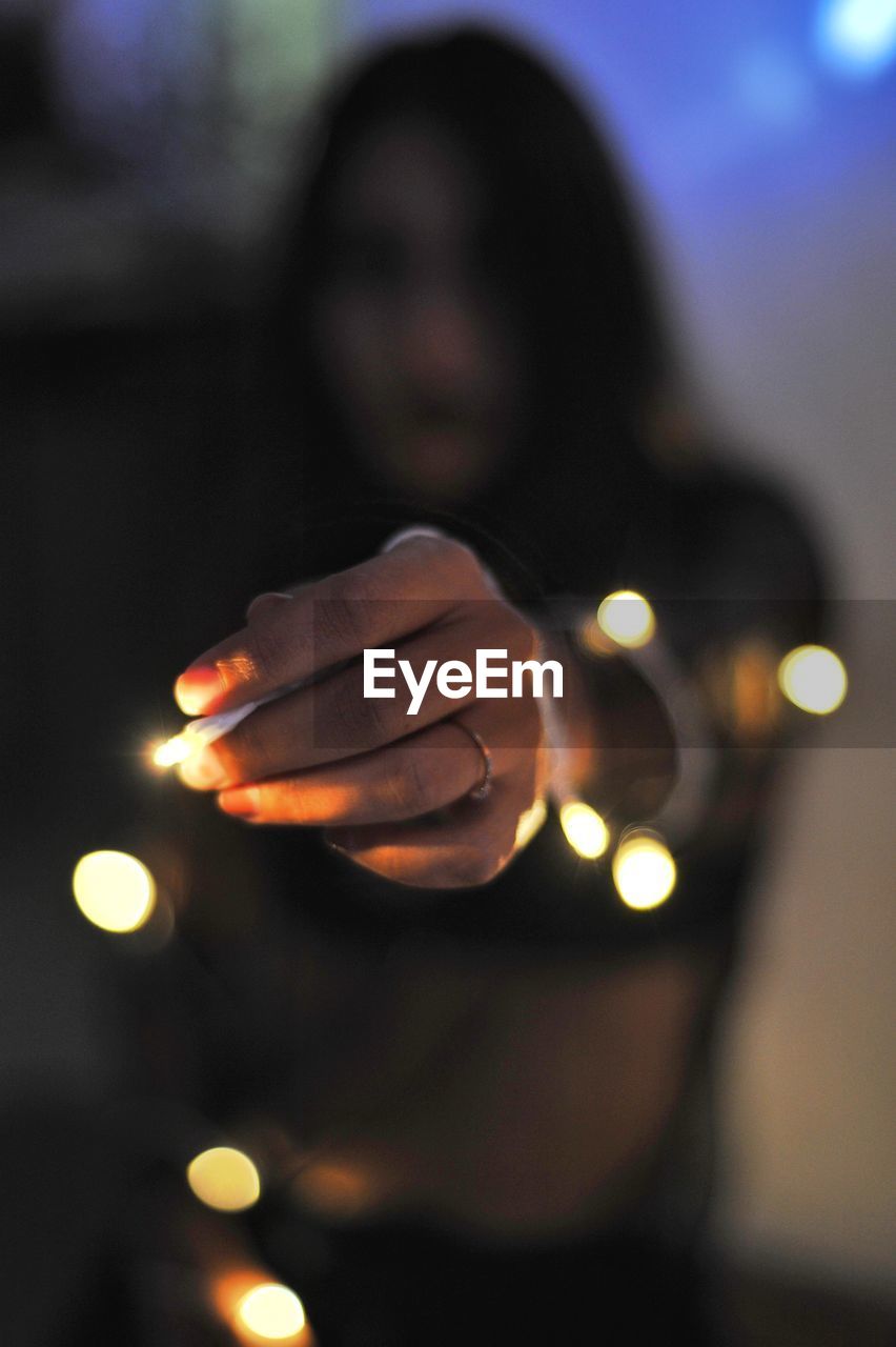 CLOSE-UP PORTRAIT OF HUMAN HAND ON ILLUMINATED LIGHT